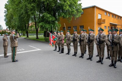 Kompania honorowa straży granicznej podczas uroczystego apelu z okazji dnia Flagi RP.  przed nimi stoi komendant karpackiego Oddziału straży granicznej, który oddaje honor przed sztandarem Oddziału.