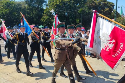 Na zdjęciu widać mężczyzn w umundurowaniu galowym różnych formacji maszerujących. W rękach trzymają sztandary