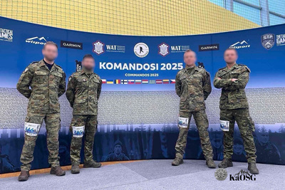 Czterech funkcjonariuszy KaOSG ubrani w moro stoją przed banerem z zawodów