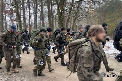Biegnący w moro na drodze leśnej żołnierze i funkcjonariusze
