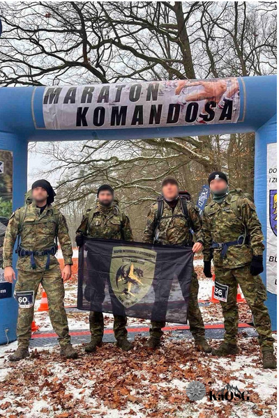 Czterech funkcjonariuszy KaOSG w moro stoi przed dmuchanym banerem Biegu Komandosa