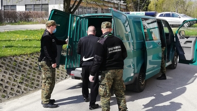 OBYWATELSTWO? BRAK. Strażnicy graniczni prowadzą mężczyznę od bramy więziennej do więźniarki