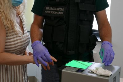 Zatrzymana przez Straż Graniczną cudzoziemka poddawana jest  badaniu daktyloskopijnemu odcisków palców. .