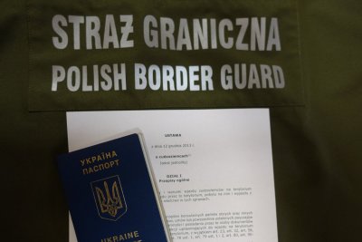 Na zielonym tle napis Straż Graniczna i Polish Border Guard. Paszport ukraiński położony na ustawie o cudzoziemcach.