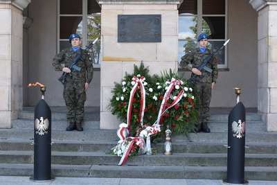 fot. kielce.ipn.gov.pl tablica upamiętniająca kieleckich obrońców Westerplatte. pod nią złożone wieńce oraz kwiaty. wystawiona warta honorowa.