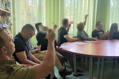 Przedstawicie NBP szkolili funkcjonariuszy i pracowników KaOSG uczestnicy szkolenia którzy sprawdzają banknoty wedle wskazań szkolącego.
