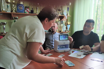 Przedstawicie NBP szkolili funkcjonariuszy i pracowników KaOSG Pani która uczestnikom szkolenia pokazuje i omawia różne problemy i próby podrobień banknotów