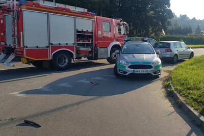 Ruszyli z pomocą pojazd służbowy Straży Granicznej, obok pojazd straży Pożarnej, obok nich pojazd uczestnika wypadku. Wszystkie pojazdy znajdują się na ulicy w pobliżu miejsca zdarzenia