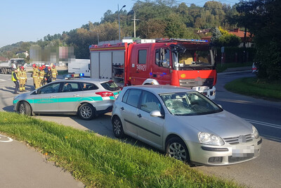 Ruszyli z pomocą na pierwszym planie pojazd uczestnika wypadku drogowego, następnie pojazdy służbowe straży granicznej oraz straży pożarnej. obok nich stojący i naradzający się funkcjonariusze Policji i straży pożarnej