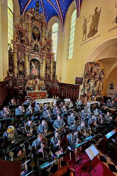 Krotoszyńska Bazylika. Około 40 funkcjonariuszy Orkiestry siedzi na krzesłach i gra na instrumentach.