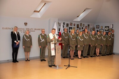 Nowi funkcjonariusze SG ślubowali w obecności Sztandaru KaOSG Sala odpraw. W tle komendant i zastępca komendanta KaOSG oraz kadra kierownicza KaOSG i przedstawicielka wojewody małopolskiego. Tyłem do nich stoi ksiądz kapelan błogosławiący nowo przyjętych funkcjonariuszy.