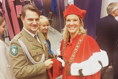Przedstawiciel SG na inauguracji roku akademickiego w Nowym Targu Komendant Placówki Straży Granicznej w Zakopanem gratulujący uściskiem dłoni Rektor Akademii Nauk Stosowanych w Nowym Targu