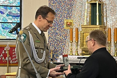 Uroczystości patriotyczne i religijno-kulturalne w Rzepienniku Strzyżewskim i Tarnowie komendant placówki straży granicznej w Tarnowie wręczający upominek proboszczowi parafii.