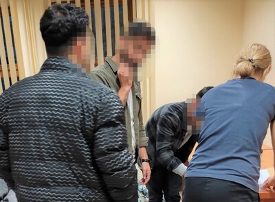 Pomieszczenia Placówki SG w Zakopanem. Funkcjonariuszka w cywilnym ubraniu zbiera podpis na dokumentach od zatrzymanego cudzoziemca. Towarzyszy im tłumacz oraz drugi z zatrzymanych cudzoziemców.