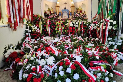Cmentarz w Wierzchosławicach. Wnętrze grobowca Wincentego Witosa. W środku kilkanaście wieńców z biało-czerwonymi szarfami.