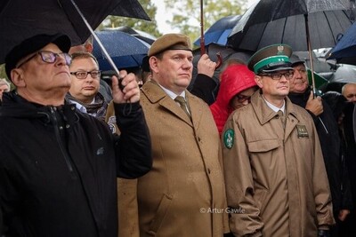 Cmentarz w Wierzchosławicach. Uczestnicy uroczystości stoją pod parasolami, wśród nich ppor. SG Paweł Sokołowski - Zastępca Komendant Placówki SG w Tarnowie.