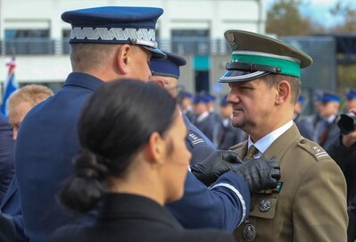 Komendant Wojewódzki Policji przypina Brązowy Medal za Zasługi dla Policji Komendantowi Placówki SG w Zakopanem. W tle funkcjonariusze Policji.