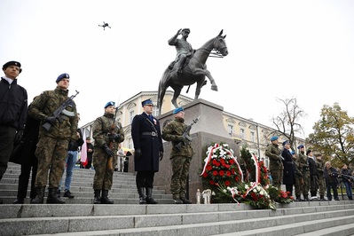 Pomnik marszałka Józefa Piłsudskiego, jadącego na koniu. Pod pomnikiem złożone wieńce i wiązanki biało-czerwonych kwiatów oraz znicze. Obok pomnika warta honorowa wystawiona przez służby mundurowe i harcerzy. W tle kamienice kieleckie.