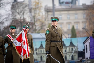 Poczet sztandarowy Kompanii Reprezentacyjnej Straży Granicznej idzie po placu Marszałka Józefa Piłsudskiego w Warszawie. Przed nim idzie z szablą dowódca - porucznik SG Piotr Jurusik.