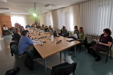Sala szkoleniowa Powiatowego Urzędu Pracy w Oświęcimiu. Uczestnicy szkolenia  i prelegenci siedzą przy dużym stole konferencyjnym.