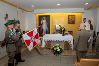 Ołtarz w Kaplicy Karpackiego Oddziału Straży Granicznej. Z lewej strony poczet sztandarowy, który prezentuje sztandar. Z lewej strony na pierwszym planie Komendant Karpackiego oddziału Straży Granicznej. Na drugim planie Ksiądz Kapelan Karpackiego Oddziału straży granicznej.