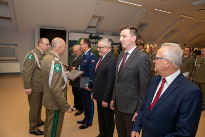 komendant karpackiego oddziału straży granicznej w asyście swojego zastępcy, wręcza odznaczenia zaproszonym gościom.