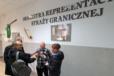 Oddali honorowo krew w Karpackim Oddziale SG wywiad z osoba odpowiedzialna za zorganizowanie akcji oddawania krwi. na drugim planie napis na ścianie Orkiestra Reprezentacyjna Straży Granicznej.