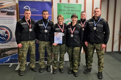 Drużyna Placówki SG w Kielcach (2 funkcjonariuszki i 4 funkcjonariuszy) stoją na tle rol-upów z pamiątkowym dyplomem oraz zawieszonymi na szyjach medalami.