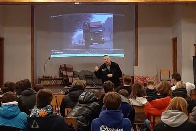 Narkotyki i handel ludźmi tematami prelekcji dla zakopiańskiej młodzieży funkcjonariusz straży granicznej prowadzący prelekcje. przed nim siedzą uczniowie biorący udział w prelekcji. za funkcjonariuszem slajd z informacjami , które są omawiane podczas spotkania.