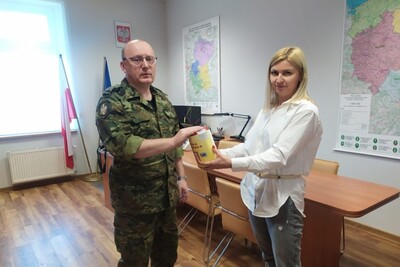 Pomieszczenie zastępcy komendanta karpackiego oddziału straży granicznej pułkownik Marcisz wrzuca zbierającej do puszki przedstawicielce Związku Zawodowego Pracowników MSWiAP datek pieniężny.