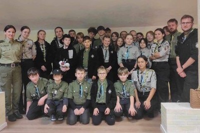 Spotkanie z harcerzami Funkcjonariuszka straży granicznej pozująca do wspólnego zdjęcia z harcerzami.