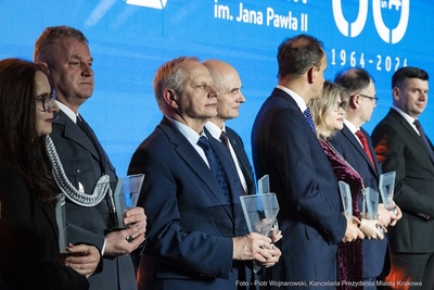 scena w Sali bankietowej, odznaczeni pamiątkowymi statuetkami stoją na scenie, wśród nich komendant kaosg