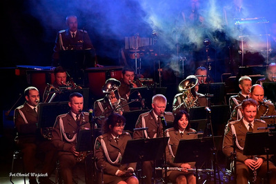 Sala koncertowa. Muzycy orkiestry reprezentacyjnej straży granicznej grający na instrumentach