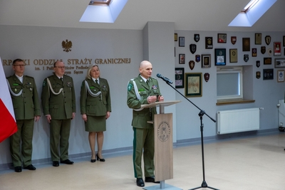 Sala Tradycji karpackiego Oddziału SG. Komendant Laciuga przemawia przy mównicy. Za nim stoją zastępcy i kapelan KaoSG