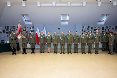 Uroczyste pożegnanie ze służbą Komendanta Placówki SG w Krakowie - fot. chor. SG Krystian Koziołek od lewej stoją: poczet sztandarowy wraz ze sztandarem Karpackiego Oddziału straży Granicznej, następnie dowództwo Karpackiego oddziału straży granicznej oraz komendanci placówek Karpackiego oddziały straży granicznej. pozują do  wspólnego zdjęcia z odchodzącym na emeryturę komendantem PSG w Krakowie.
