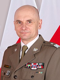 Zdjęcie odchodzącego na emeryturę Komendanta Karpackiego Oddziału Straży Granicznej. W tle flagi Polski.