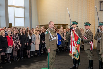 Komendant obejmujący stanowisko Komendanta Karpackiego Oddziału Straży Granicznej stojący przed Sztandarem Karpackiego Oddziału Straży Granicznej. Na drugim planie stoją pracownicy Karpackiego Oddziału Straży Granicznej.