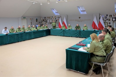 Sala tradycji kaosg. Przy stołach ułożonych w kształcie litery u siedzi kadra kierownicza oddziału, na czele z komendantem i jego zastępcami.