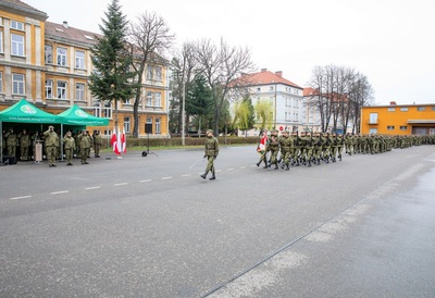 Plac apelowy w komendzie karpackiego oddziału straży granicznej. Defilada pododdziałów biorących udział w  uroczystym apelu. W tle po lewej stronie kadra kierownicza oddziału na czele z komendantem oddają honor sztandarowi kaosg