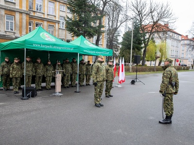 Plac apelowy w komendzie karpackiego oddziału straży granicznej. Dowódca uroczystości melduje komendantowi kaosg zakończenie uroczystości, w tle pod zadaszeniem stoi kadra kierownicza oddziału