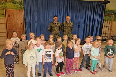 dzieci oraz funkcjonariusze straży granicznej pozujący do wspólnego zdjęcia.
