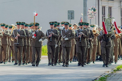 Funkcjonariusze orkiestry reprezentacyjnej straży granicznej idą w zwartym szyku prowadzeni przez tamburmajora z podniesiona buławą