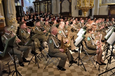 Wnętrze bazyliki w limanowej. muzycy orkiestry grają na instrumentach. na pierwszym planie sekcja dęta