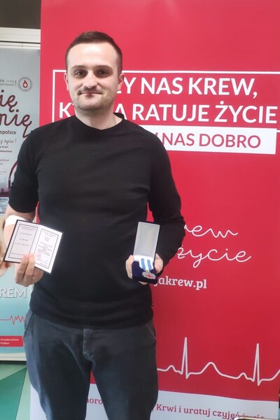 Funkcjonariusz który otrzymał odznaczenie. W rękach trzyma legitymację oraz przyznane odznaczenie