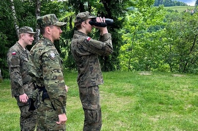 Funkcjonariusze SG przekazali lornetkę uczniowi w mundurze, ten patrzy w dal
