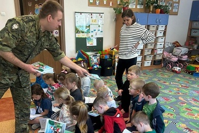 funkcjonariusz sg rozdaje przedszkolakom malowanki