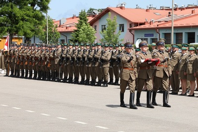 poczet flagowy idzie przed pododdziałami w stronę masztu by umieścić flagę na maszt podczas uroczystości rocznicowych sg w nowym sączu