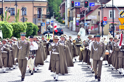 orkiestra reprezentacyjna idzie w przemarszu. na jej czele od lewej idzie naczelnik orkiestry, następnie w środku tamburmajor orkiestry, a po prawej stronie zastępca naczelnika.
