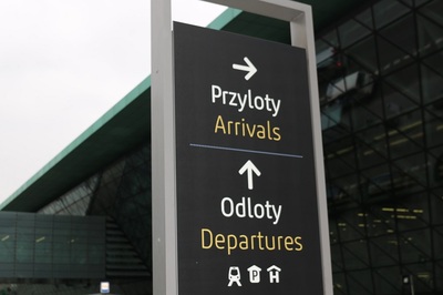 Na zdjęciu widać napisy przyloty, odloty na tle terminala portu lotniczego