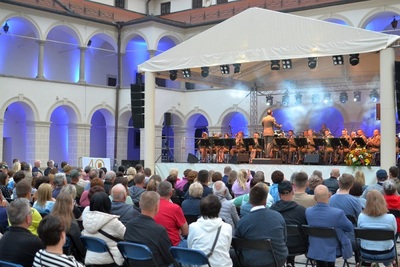Dziedziniec Zamku Suskiego, publiczność siedzi pod sceną. na scenie gra orkiestra reprezentacyjna SG